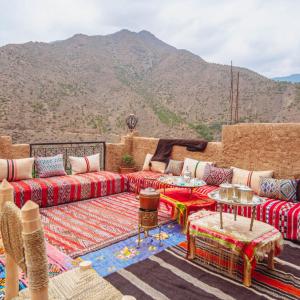 een woonkamer met banken en uitzicht op een berg bij Atlas Kasbah Lodge in Imlil