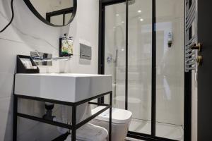 ein Badezimmer mit einem weißen Waschbecken und einer Dusche in der Unterkunft Duplo Charme Boutique Hotel in Lissabon