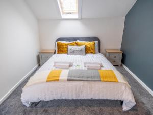 a bedroom with a large bed with yellow and white at Pass the Keys Beautiful flat near Nottingham city with parking in Nottingham