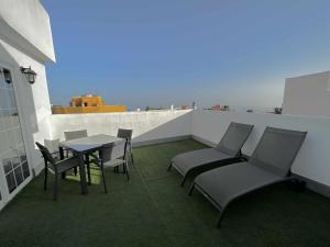 a balcony with a table and chairs on a roof at Atico eloy delgado in San Miguel de Abona
