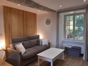 een woonkamer met een bank en een tafel bij Studio meublé avec terrasse axe Rennes Saint Malo in La Baussaine