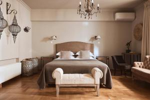 a bedroom with a bed and a chair and a chandelier at Plaka's Villa with Breathtaking Acropolis view in Athens
