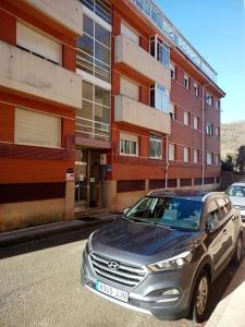 un coche plateado estacionado frente a un edificio en La Plata VUT LE 0614, en León