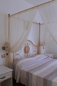a bedroom with a white bed with a canopy at Guest House Bellavista Nebida in Nebida
