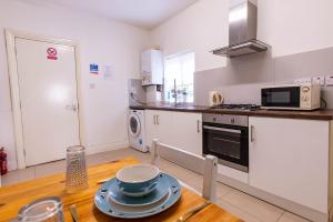 a kitchen with a table with plates on it at 090 Luxury 1 bedroom flat near Luton Town and station in Luton