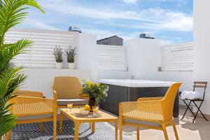 un patio con sillas, una mesa y una parrilla en Magno Apartments Feria 132 en Sevilla