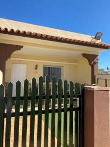 a green fence in front of a house at Apartamentos Turísticos Carmencita in Bolonia