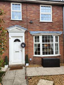 a brick house with a white door and windows at Boutique Abode - With Hot Tub in Chester
