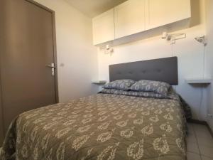 1 dormitorio con 1 cama con edredón marrón en Résidence AZUR1 Appartement 251, en Le Lavandou