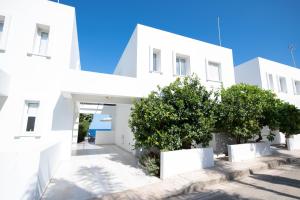 a white building with trees in front of it at Jasmine Sea Front Villa in Protaras