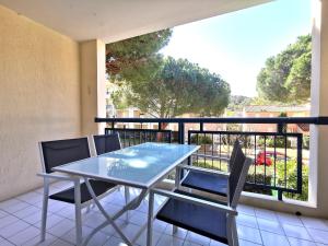 una mesa azul y sillas en el balcón en Résidence AZUR1 Appartement 251, en Le Lavandou