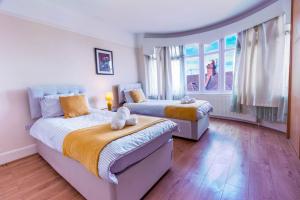 a bedroom with two beds and a large window at 3 bedroom House for Contractors,Workers,Relocation,Insurance,Family, Free Parking, Ashburnham 1 in Luton