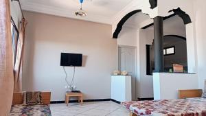 sypialnia z łóżkiem i telewizorem na ścianie w obiekcie Afgo Hostel w mieście Warzazat