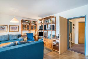 a living room with a blue couch and a tv at Appartment 160, 80qm in Obertal