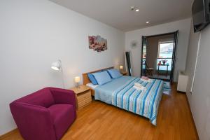 1 dormitorio con cama y silla morada en Sea View Porto, en Dubrovnik