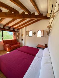 a bedroom with a large bed and a red couch at Can Pera Accommodation - TI in Fornalutx +105 photos