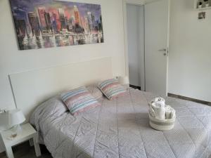 リニャーノ・サッビアドーロにあるArnica Apartmentのベッドルーム1室(枕2つ、絵画付)