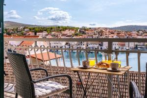 uma mesa e cadeiras numa varanda com vista para a água em Villa Trebotić em Milna