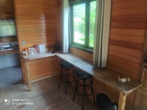 eine Küche mit einer Bar in einer Hütte mit einem Fenster in der Unterkunft Vila Sol Cabana in Lontras