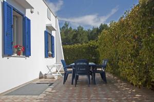 un tavolo e sedie seduti su un patio di Acquamarina di Mancaversa a Marina di Mancaversa