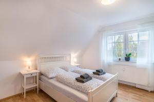 a bedroom with a white bed and a window at Apartement Aposto 3 in Oberderdingen