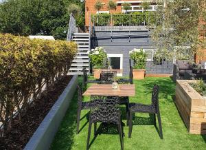 a patio with a table and chairs on the grass at Hotel Collingwood BW Signature Collection in Bournemouth
