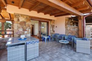 a kitchen and living room with a stone wall at Villa Caterina con depandance in Monte Petrosu