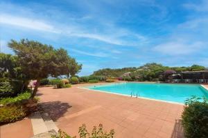 a large swimming pool in a yard with a tree at Villa Caterina con depandance in Monte Petrosu
