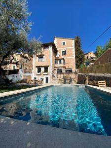 a swimming pool in front of a building at Can Pera Accommodation - TI in Fornalutx