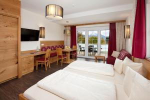 Habitación de hotel con cama y comedor en Landhotel Schwarzenbach - Wellness & Spa en Rieden