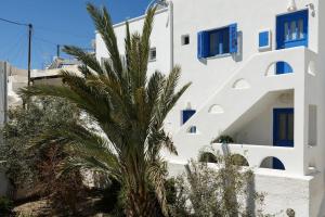 a palm tree in front of a white building at Elegant Cycladic Villa in Emporio Santorini
