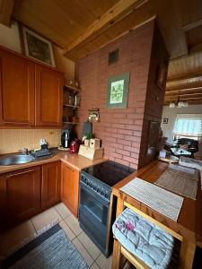 a kitchen with wooden cabinets and a stove top oven at Domek w Gaju in Gaj Grzmięca +15 photos