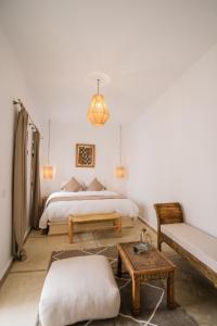 a bedroom with a bed and a couch and a table at Riad Rahal in Marrakech