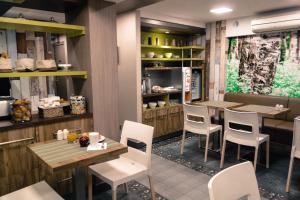 a restaurant with wooden tables and white chairs at Prince Albert Wagram in Paris