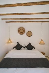 1 dormitorio con cama blanca y almohadas negras en Riad Rahal en Marrakech