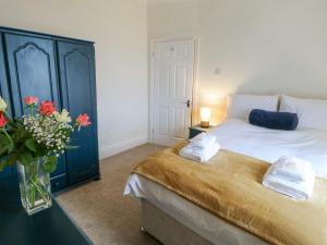 a bedroom with a bed and a vase of flowers at Fellend House in Bishop Auckland