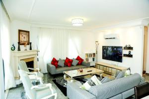 a living room with a couch and a tv at Stunning 4 bedrooms Luxury Villa Kaan Dalyan in Dalyan