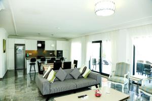 a living room with a couch and a kitchen at Stunning 4 bedrooms Luxury Villa Kaan Dalyan in Dalyan