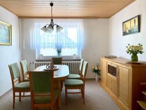 eine Küche und ein Esszimmer mit einem Tisch und Stühlen in der Unterkunft Charmantes Ferienhaus Gernrode/ Harz, Balkon, Grill, 2 Schlafzimmer in Quedlinburg