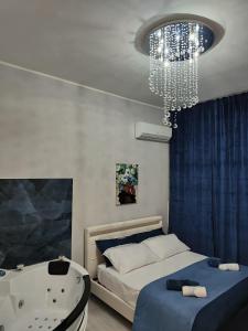 1 dormitorio con bañera, cama y lámpara de araña en Apartments for rent Catania, en Catania