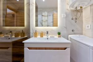 - une salle de bains blanche avec deux lavabos et un miroir dans l'établissement Zlatibor apartmani Kika, à Zlatibor