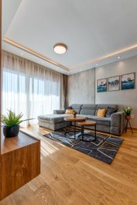 ein Wohnzimmer mit Sofa und Tisch in der Unterkunft Zlatibor Apartman & SPA Pino Mons in Zlatibor
