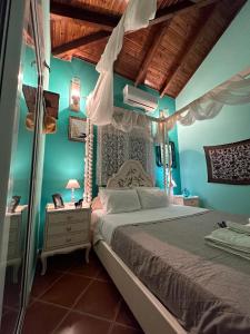 a bedroom with a large bed with blue walls at Saronic Seafront in Salamina