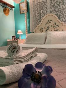 a bedroom with a bed with towels and a flower on the floor at Saronic Seafront in Salamís