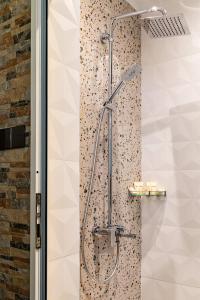 um chuveiro na casa de banho com uma parede de azulejos em Sofiel cozy apartment - Top Center Sofia em Sófia