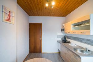 a bathroom with a sink and a wooden ceiling at Csini vendégház in Balatonföldvár