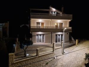 a large white building with a fence in front of it at night at Villa Olivetum in Marina