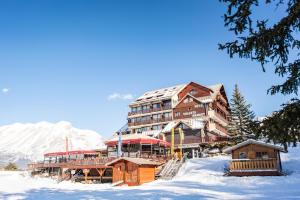 a large building on top of a snow covered mountain at Hôtel Chalets Margot in Le Dévoluy