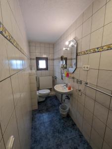a bathroom with a sink and a toilet and a mirror at Hotel Eiserner Anton in Bielefeld