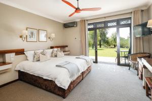 een slaapkamer met een groot bed en een groot raam bij Ilala Lodge Hotel in Victoria Falls